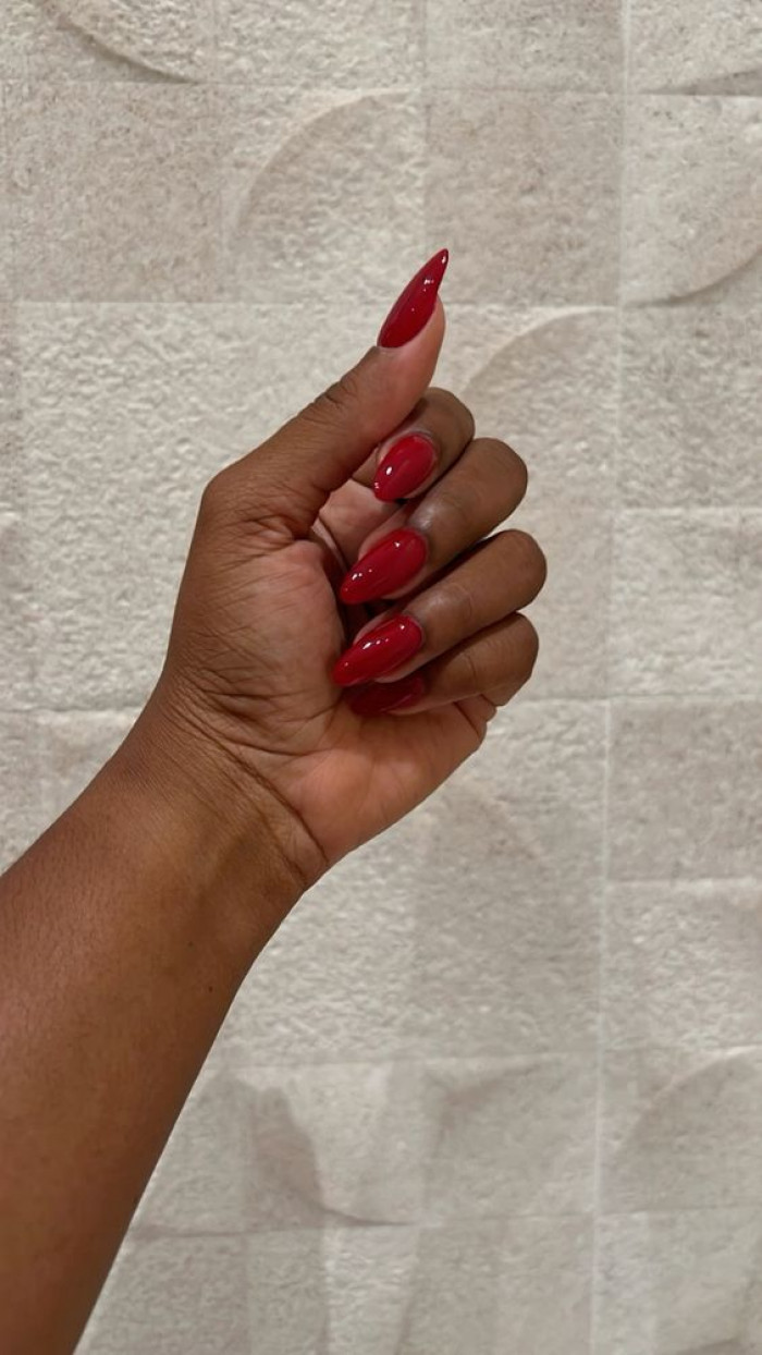 Uñas con brillo rojo intenso sobre piel morena oscura